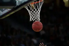 A shot dropping at the rim, the crowd dark behind
